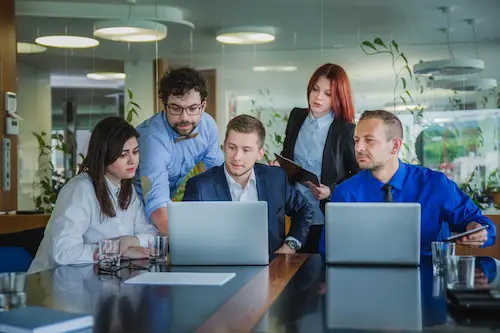 Development team reviewing a project together on laptops